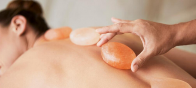 Warm Himalayan salt stone massage therapy at Soothe and Sage in Spokane WA - natural mineral detox and deep muscle relief